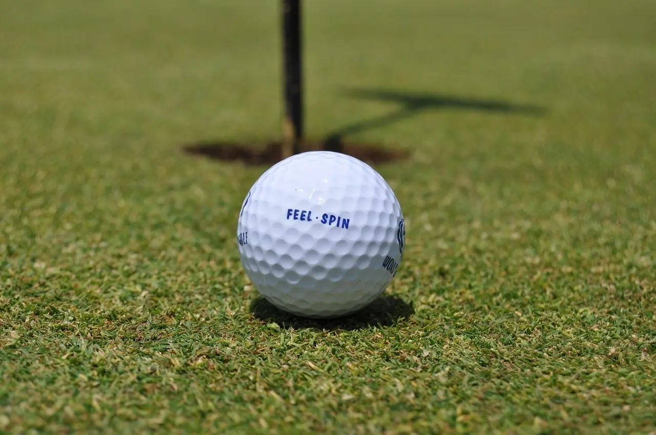 Golfbold tæt ved hul på green