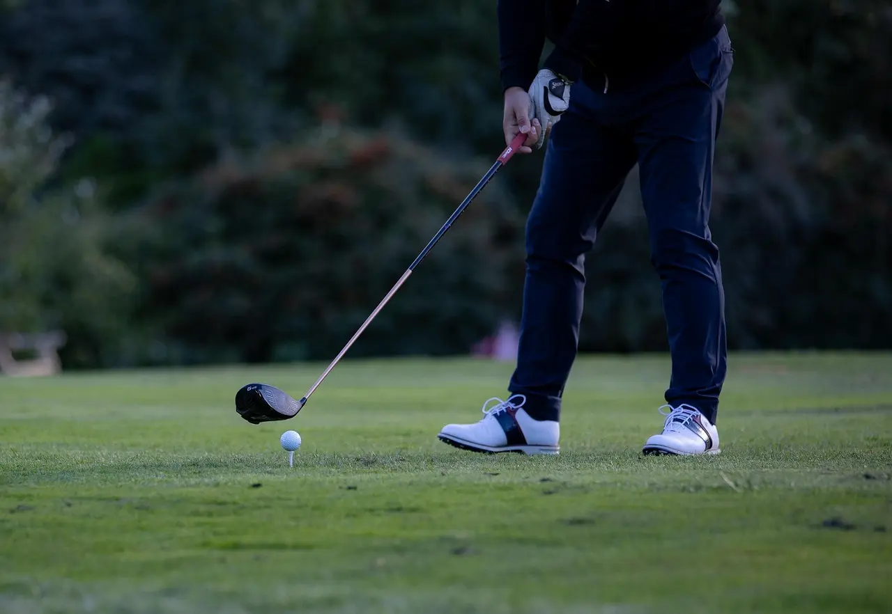Golfspiller ved teestedet med driver